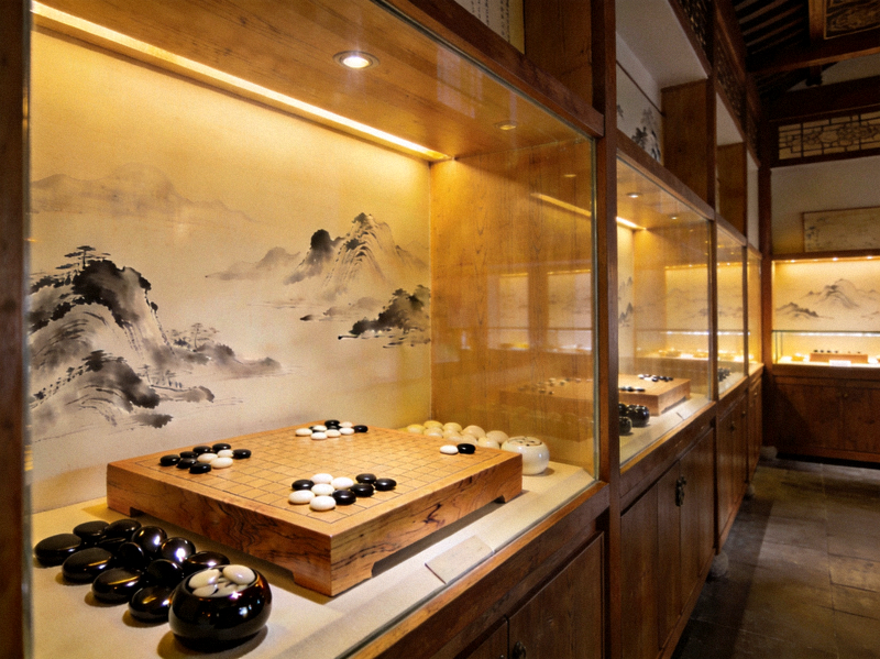 悠扬棋牌文化展厅内陈列的传统木质棋盘与黑白棋子，墙面点缀水墨山水装饰